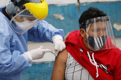 (200821) -- LIMA, 21 agosto, 2020 (Xinhua) -- Una trabajadora médica aplica una vacuna a un hombre para prevenir la influenza como parte de una campaña de salud durante el estado de emergencia sanitaria en la municipalidad de Villa María del Triunfo, en Lima, Perú, el 21 de agosto de 2020. Cines, teatros, gimnasios y hasta casinos empiezan a tomar su ritmo en una "nueva normalidad" por la enfermedad causada por el nuevo coronavirus (COVID-19) en América Latina, mientras algunos países participan en la fase 3 para probar una vacuna que ayude a combatir el virus. (Xinhua/Mariana Bazo) (mb) (mm) (vf) (dp) 
