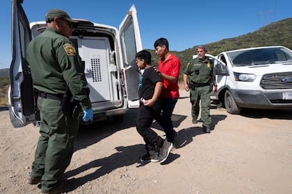Agentes de la Patrulla Fronteriza de EE.UU. reteniendo a un grupo de migrantes cerca de Dulzura, California (Archivo Foto AP/Gregory Bull)