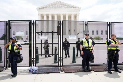 Agentes vigilan el exterior de la Corte Suprema, en Washington, el viernes 24 de junio de 2022, después de que decidiera anular el fallo Roe vs. Wade que atañe al derecho de las mujeres al aborto en Estados Unidos. (AP Foto/Jacquelyn Martin)