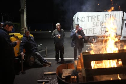Agricultores se reúnen en una barbacoa mientras bloquean una carretera en señal de protesta
 (AP Photo/Christophe Ena)