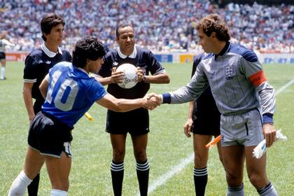 Ali Bin Nasser controla la pelota, mientras Diego Maradona y Peter Shilton se saludan en la ceremonia previa al partido; el árbitro tunecino, recordado como "Ali Bennaceur", es el dueño del balón.
