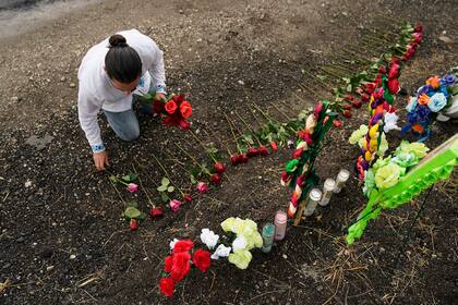 ARCHIVO - Carlow Eduardo Espina coloca el martes 28 de junio de 2022 unas rosas en un altar improvisado instalado en el lugar donde las autoridades estadounidenses encontraron a decenas de personas muertas dentro de un tractocamión en San Antonio, Texas. (AP Foto/Eric Gay/Archivo)
