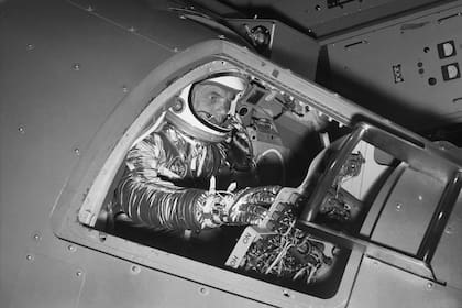 ARCHIVO - En esta fotografía de archivo del 11 de enero de 1961, John Glenn, en ese entonces teniente coronel de la infantería de Marina, maneja un simulador de una cápsula Mercury ante los periodistas, en el Centro de Investigación de la NASA en Langley Field, Virginia. (AP Foto/archivo)