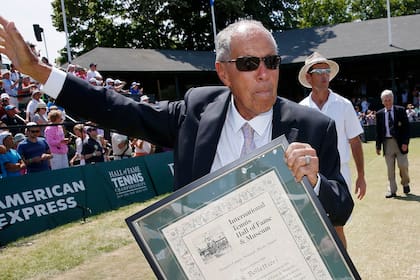 ARCHIVO - Nick Bollettieri sostiene una placa de reconocimiento tras ingresar como miembro al Salón de la Fama del tenis en Newport, Rhode Island, el 12 de julio de 2014 (AP Foto/Michael Dwyer)