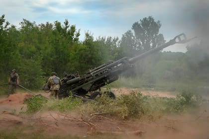 ARCHIVO - Soldados ucranianos disparan contra posiciones rusas con un obús M777 suministrado por Estados Unidos en la región oriental de Donetsk el 18 de junio del 2022.  (AP Foto/Efrem Lukatsky)