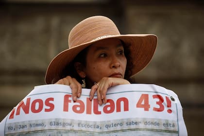 ARCHIVO - Una mujer lleva una pancarta que hace referencia a los 43 estudiantes desaparecidos de una escuela rural de maestros, durante una marcha el jueves 26 de noviembre de 2015, en la Ciudad de México. (Foto AP/Eduardo Verdugo, archivo)