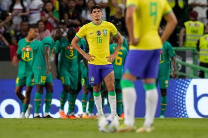 Ayrton Lucas busca una explicación a la debacle de Brasil; detrás, el festejo senegalés en Lisboa