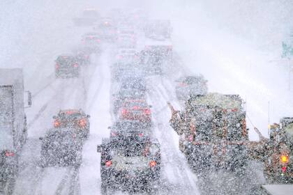 Barredoras, a la derecha, intentan avanzar entre el tráfico prácticamente detenido debido a las condiciones climáticas, el martes 15 de marzo de 2023 sobre la ruta 93 Sur, en Londonderry, Nueva Hampshire. (AP Foto/Charles Krupa)