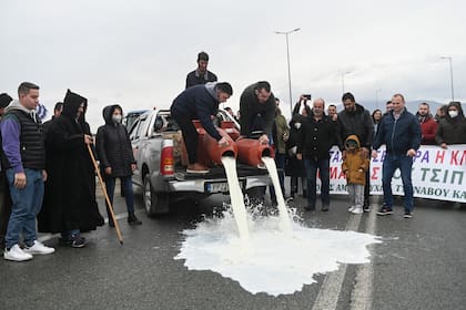 Campesinos griegos lanzan leche como protesta en cerca de Larissa en el centro de Grecia, el 13 de febrero del 2022. (Foto AP/Giannis Papanikos)