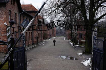 Cerca de la puerta del antiguo campo de concentración y extermino nazi de Auschwitz-Birkenau, con la frase ''Arbeit Macht Frei" ("El trabajo os hará libres"), en Oswiecim, Polonia, el 26 de enero de 2023. (AP Foto/Michal Dyjuk)