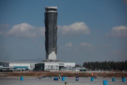 Con la torre de control de tráfico aéreo como telón de fondo, varios obreros trabajan en el Aeropuerto Internacional Felipe Ángeles, el 31 de enero de 2022, en las afueras de Ciudad de México. (AP Foto/Ginnette Riquelme, Archivo)