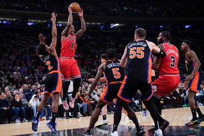 DeMar DeRozan de los Bulls de Chicago intenta pasar el balón mientras lo defienden varios jugadores de los Knicks de Nueva York en el encuentro del viernes 23 de diciembre del 2022. (AP Foto/Seth Wenig)