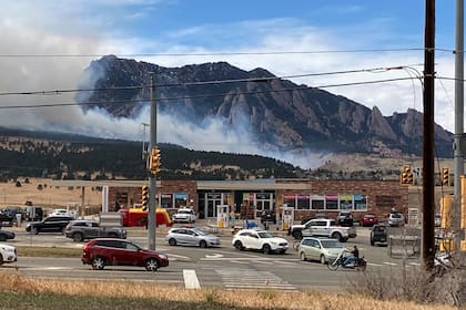 Dos bomberos avanzan junto a un área quemada por un incendio forestal, el domingo 27 de marzo de 2022, en Boulder, Colorado. (AP Foto/David Zalubowski)