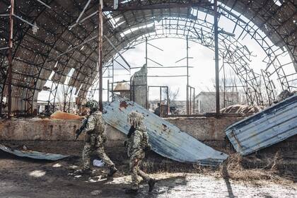 Dos soldados, del ejército ucraniano, caminan por una antigua fábrica destruida por la guerra en la línea del frente, a 19 de febrero de 2022, en Avdiivka, Oblast de Donetsk (Ucrania)