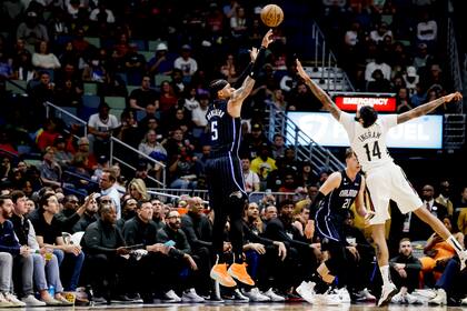 El alero del Magic de Orlando Paolo Banchero lanza el balón sobre el alero de los Pelicans de Nueva Orleans Brandon Ingram en el encuentro del lunes 27 de febrero del 2023. (AP Foto/Derick Hingle)