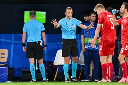 El árbitro Michael Oliver chequea el VAR durante el partido entre Alemania y Dinamarca, polémicas varias también hay en la Eurocopa, pero el tiempo de demora para resolver un fallo es menor