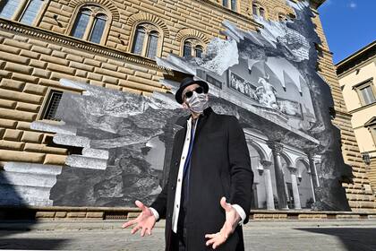 El artista francés conocido como JR posa durante la inauguración de la instalación visual "La Ferita", en la fachada del renacentista Palazzo Strozzi en Florencia, Italia
