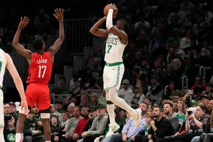 El base de los Celtics de Boston Jaylen Brown lanza un triple sobre el alero de los Rockets de Houston Tari Eason en el encuentro del martes 27 de diciembre del 2022. (AP Foto/Charles Krupa)
