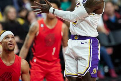 El base de los Lakers de Los Ángeles Dennis Schroder dispara frente a la mirada del escolta de los Trail Blazers de Portland Josh Hart en la segunda mitad del partido del domingo 22 de enero de 2023, en Portland, Oregon. (AP Foto/Craig Mitchelldyer)