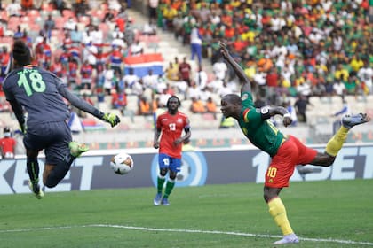 El camerunés Vincent Aboubakar cabecea sin éxito al arco defendido por el gambiano Baboucarr Gaye en partido por la Copa Africana de Naciones en Duala, Camerún, sábado 29 de enero de 2022. Camerún ganó 2-0. (AP Foto/Sunday Alamba)
