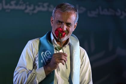 El candidato reformista a las elecciones presidenciales de Irán, Masoud Pezeshkian, huele una flor durante un mitin de campaña en Teherán, Irán