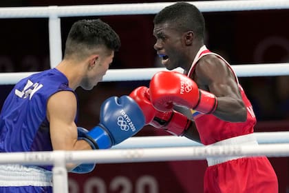 El colombiano Yuberjen Martínez (derecha) intercambia golpes con el japonés Ryomei Tanaka en la pelea de peso mosca de los Juegos Olímpicos de Tokio, el martes 3 de agosto de 2021. (AP Foto/Themba Hadebe)