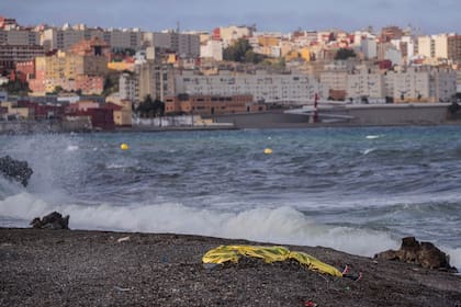 El cuerpo de un joven, cubierto con una sábana térmica tras ser recuperado por la policía española en aguas próximas a la frontera entre Marruecos y el enclave español de Ceuta, en el norte de África, el 20 de mayo de 2021. (AP Foto/Bernat Armangue)