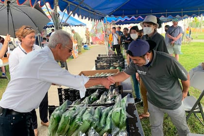 El embajador de Estados Unidos en Japón, Rahm Emanuel, saluda a un vendedor local en el mercado de agricultores de Camp Hansen, una base del Cuerpo de Marines de EEUU, en la isla de Okinawa, en el sur de Japón, el domingo 30 de octubre de 2022. (Foto, embajada de EEUU vía AP)