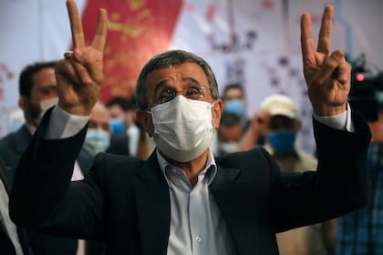 El expresidente Mahmoud Ahmadineyad hace el signo de la victoria con dos dedos en alto mientras se registra como candidato para las presidenciales del 18 de junio, en el Ministerio del Interior, en Teherán, Irán, el 12 de mayo de 2021. (AP Foto/Vahid Salemi)