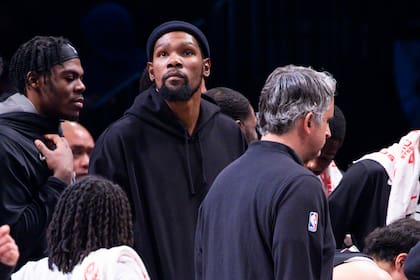 El jugador de los Nets de Brooklyn Kevin Durant, en el centro, mira desde la banca en la segunda mitad de su juego de NBA contra los Lakers de Los Ángeles, el lunes 30 de enero de 2023 en Nueva York. (AP Foto/Corey Sipkin)