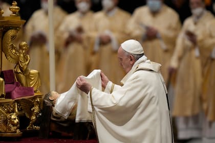 El papa Francisco devela una estatua del niño Jesús en la Misa de Gallo en la Basílica de San Pedro, en el Vaticano, el 24 de diciembre del 2021. (AP Foto/Alessandra Tarantino)