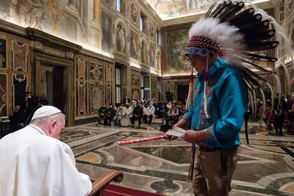 El Papa recibe un regalo del jefe de una delegación de indígenas de Canadá en el Vaticano, en abril de 2022