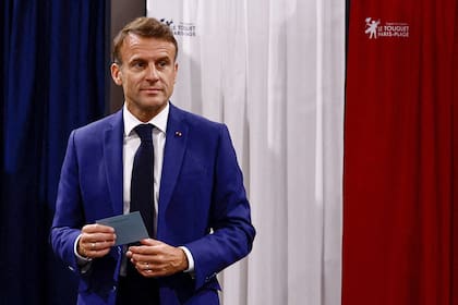 El presidente de Francia, Emmanuel Macron, abandona la cabina electoral antes de emitir su voto en la primera ronda de las elecciones parlamentarias en una mesa electoral en Le Touquet, al norte de Francia