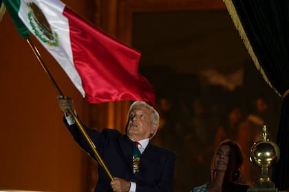 El presidente mexicano Andrés Manuel López Obrador ondea la bandera nacional desde el balcón del Palacio Nacional durante las celebraciones por el Día de la Independencia, en la Ciudad de México, el miércoles 15 de septiembre de 2021. (AP Foto/Fernando Llano)