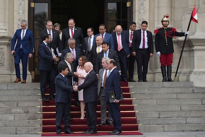 El presidente peruano Pedro Castillo, al frente a la izquierda, estrecha las manos de Eladio Loizaga, miembro de una delegación de la Organización de los Estados Americanos, al término de una reunión en el palacio de gobierno en Lima, el lunes 21 de noviembre de 2022. (AP Foto/Guadalupe Pardo)