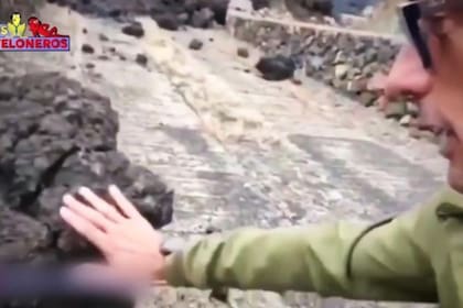 El reportero tocó la piedra volcánica mientras se grababa