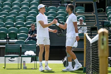 El saludo entre Jannik Sinner y Novak Djokovic, en el court central del All England, donde compartieron un entrenamiento