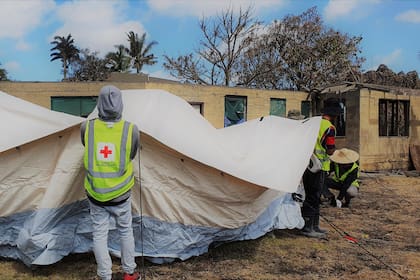 En esta foto proporcionada por la Sociedad de Cruz Roja de Tonga, personal de Cruz Roja instala un refugio temporal en Sopu, Nukualofa, el sábado 22 de enero de 2022, mientras la nación insular de Tonga lidiaba con los efectos de una erupción volcánica submarina y un tsunami. (Sociedad de Cruz Roja de Tonga via AP)