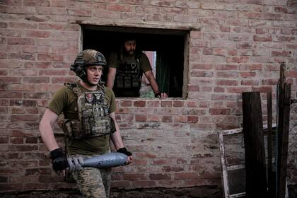 En esta fotografía proporcionada por el servicio de prensa de la 24ta brigada, soldados ucranianos se preparan para lanzar un mortero de 120mm hacia una posición rusa en la línea del frente, en la región de Donetsk, Ucrania, el lunes 4 de junio de 2024. (Oleg Petrasiuk/Ukrainian 24 Mechanised brigade vía AP)