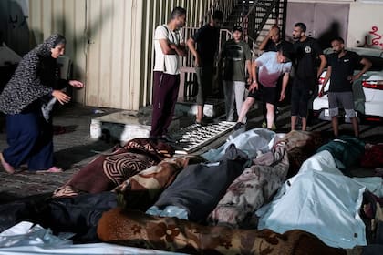 En esta fotografía tomada frente a la morgue del hospital Mártires de Al Aqsa en Deir al-Balah, en la Franja de Gaza, el jueves 6 de junio de 2024, varios palestinos lloran por sus familiares muertos por un bombardeo israelí contra una escuela de la ONU en el campamento de refugiados de Nusseirat. (AP Foto/Abdel Kareem Hana)