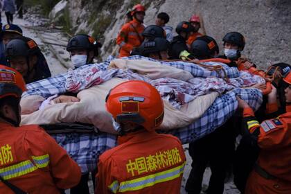 En esta imagen, distribuida por la agencia noticiosa Xinhua, rescatistas trasladan a sobrevivientes luego de un sismo en la localidad de Moxi, en el condado de Luding de la provincia de Sichuan, en el suroeste de China, el 5 de septiembre de 2022. (Cheng Xueli/Xinhua vía AP)