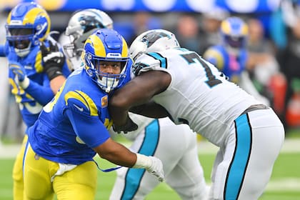 En foto del 16 de octubre del 2022, el defensive tackle de los Rams de Los Ángeles Aaron Donald intenta superar al offensive tackle de los Panthers de Carolina Taylor Moton. (AP Foto/Jayne Kamin-Oncea)
