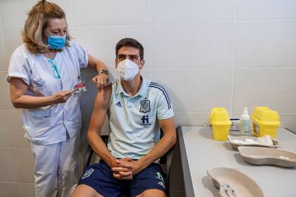En imagen proporcionada por la Real Federación Española de Fútbol (RFEF), Gerard Moreno recibe una dosis de la vacuna contra COVID-19, en el complejo deportivo Las Rozas de Madrid, España, el viernes 11 de junio de 2021. (Pablo García/RFEF vía AP)