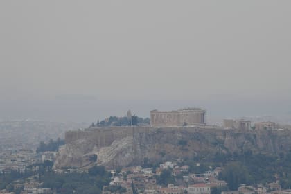 Esta foto del jueves, 20 de mayo del 2021, muestra una vista del Partenón y la ciudad de Atenas envueltos en humo causado por un incendio forestal cerca de la aldea de Schinos, junto a Corintos. El incendio ha destruido viviendas y forzado evacuaciones.  (AP Foto/Michalis Varaklas)