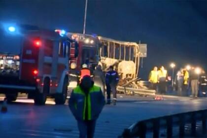 Esta imagen tomada de un video proporcionado por Nova TV muestra a trabajadores del servicio de emergencias junto a un autobús quemado en Bosnek, Bulgaria, el martes 23 de noviembre de 2021. (Nova TV via AP)