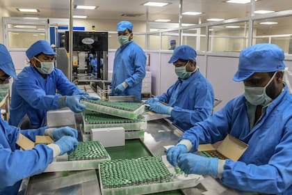 Un grupo de operarios empaca vacunas en el Serum Institut de la India