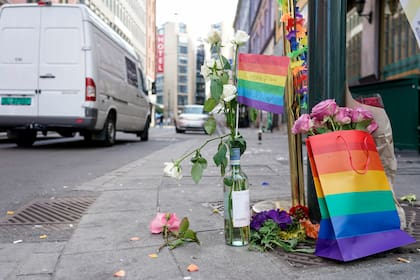 Flores acompañadas por los colores del orgullo gay yacen en el sitio donde un hombre armado se puso a disparar, el sábado 25 de junio de 2022, en el centro de Oslo. (Hakon Mosvold Larsen/NTB Scanpix vía AP)