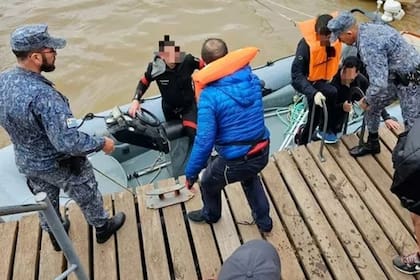Integrantes de la Armada de Uruguay ofrecen asistencia a los tripulantes argentinos cuyo velero se hundió en el Río de la Plata