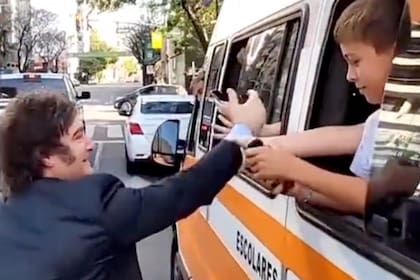 Javier Milei rumbo a Olivos se bajó del auto y saludó a varios niños que viajaban en un transporte escolar