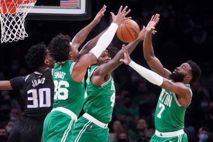 Jaylen Brown (7),  Marcus Smart (36) y Robert Williams III (44), de los Celtics de Boston, disputan un rebote con Damian Jones (30), de Kings de Sacramento durante el primer cuarto del juego de la NBA el martes 25 de enero de 2022, en Boston. (AP Foto/Charles Krupa)